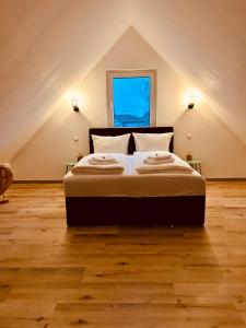sypialnia z dużym łóżkiem na poddaszu w obiekcie Apartments Maxim w mieście Rust