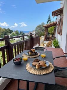 a table with two plates of food on a balcony at Villa Flower in Skiathos