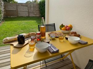 - une table avec de la nourriture et des boissons ainsi qu'un bol de fruits dans l'établissement La Pause de Mérimée - Jardin - Parking, à Vannes