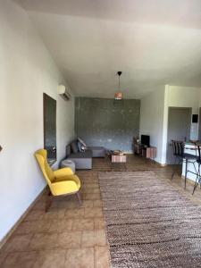 a living room with a yellow chair and a couch at Villa Flower in Skiathos