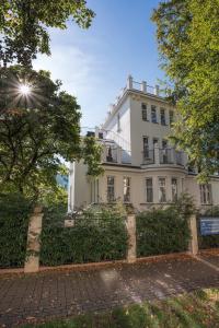 a white building with trees in front of it at Apartments Villa Whitehouse in Ostrava