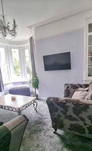 uma sala de estar com um sofá e uma mesa em Purbeck Lodge em Swanage