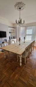 a dining room table with chairs and a chandelier at Purbeck Lodge in Swanage