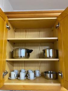 a cabinet with cups and pots and pans in it at Castle House Xativa in Xàtiva