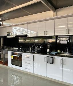 HOTEL CASA LUKE في نيفا: مطبخ كبير مع الدواليب والاجهزة البيضاء