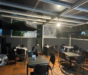 a dining room with tables and chairs and umbrellas at HOTEL CASA LUKE in Neiva