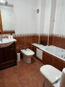 a bathroom with a tub and a toilet and a sink at Castle House Xativa in Xàtiva