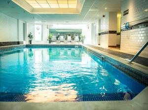 a swimming pool with blue water in a building at Royal Hotel in Forfar
