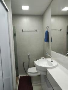 a bathroom with a toilet and a sink and a shower at Apartamento frente ao mar condomínio Jubiabá ilhéus olivença in Olivença