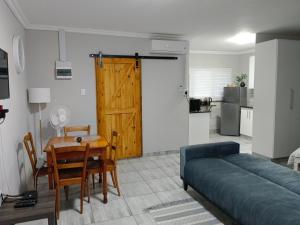 a living room with a couch and a table and a door at Blissful Stays in Richards Bay