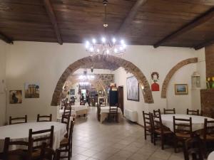 une salle à manger avec tables et chaises et un lustre dans l'établissement Gallo - La Cantina del contadino, à Rende