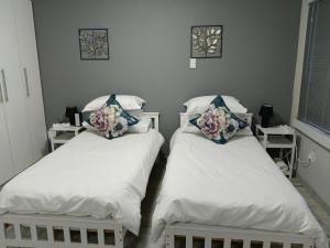 two beds in a hospital room with flowers on them at Blissful Stays in Richards Bay