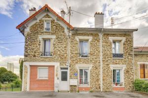 ein altes Steinhaus mit weißen Türen und Fenstern in der Unterkunft *Au Bord du Canal*Entre Paris et Disneyland in Chelles