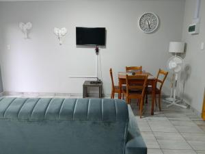 a living room with a table and a tv at Blissful Stays in Richards Bay