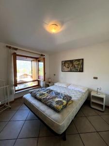 ein Schlafzimmer mit einem Bett in einem Zimmer mit einem Fenster in der Unterkunft Appartamento Lucia Vacanze nel centro di Folgarida 11 in Folgarida