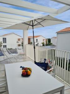 a white table with a bowl of fruit on a patio at Pareus Beach Resort in Caorle
