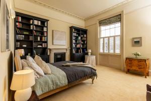 a bedroom with a bed and a fireplace and a window at Pittville House in Cheltenham