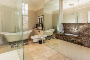 a bathroom with a tub and a toilet and a sink at Pittville House in Cheltenham