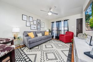 a living room with a couch and a red chair at Home Away From Home with King Bed, WiFi and Lots of Amenities in Killeen