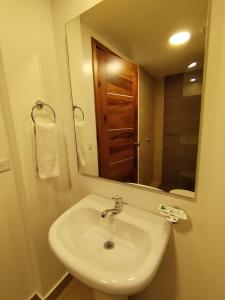 a bathroom with a white sink and a mirror at Airos Hotel in Baños