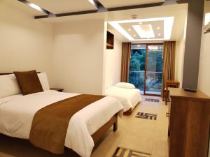 Airos Hotel في بانوس: غرفة نوم بسريرين ونافذة