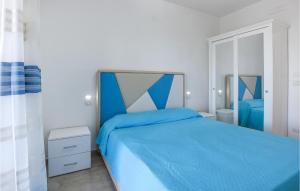 - une chambre avec un lit bleu et un miroir dans l'établissement 2 Bedroom Nice Apartment In Castellabate, à Castellabate