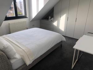 um quarto com uma cama branca e uma mesa em Perfect Pad for Solo Travelers em Norwood