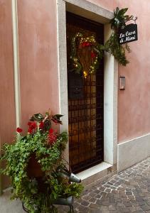 a front door of a pink building with a plant at La Casa Di Mimi in Bardolino +50 photos