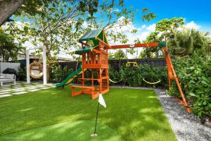 - une aire de jeux dans une cour avec balançoire dans l'établissement The World Mansion 22 Guest Heated Pool Canal View, à Tamiami