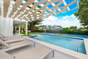 une piscine extérieure avec une pergola. dans l'établissement The World Mansion 22 Guest Heated Pool Canal View, à Tamiami