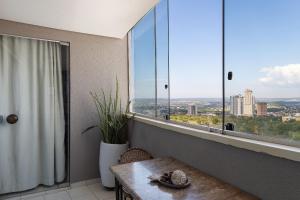 a room with a table and a large window at Unique Residence, close to Park and Shopping Flamboyant in Goiânia