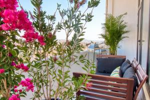 un sofá en un balcón con flores rosas en Liwan Hotel, en Amán