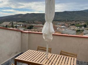 - une table avec un parasol sur le balcon dans l'établissement Casa en Vilanova de Meià, à Vilanova de Meyá
