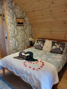 a bedroom with a bed in a wooden room at Beautiful Glamping Pod with Central Heating, Hot Tub, Garden, Balcony & views - close to Cairnryan - The Herons Nest by GBG in Glenluce