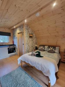 a bedroom with a bed in a log cabin at Beautiful Glamping Pod with Central Heating, Hot Tub, Garden, Balcony & views - close to Cairnryan - The Herons Nest by GBG in Glenluce