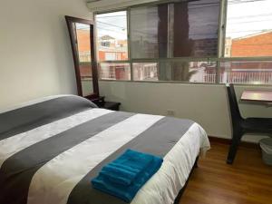 um quarto com uma cama, uma secretária e uma janela em Casa 30 em Bogotá