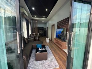 - un salon avec un canapé et une télévision dans l'établissement Luxury Private Pool Villa- Ao Nang Krabi, à Ao Nam Mao