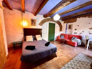 1 dormitorio con 1 cama y 1 sofá rojo en Estudio en masía Can Mon, en Anglés