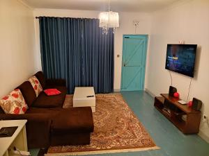 a living room with a couch and a flat screen tv at Graceland 2 in Nakuru