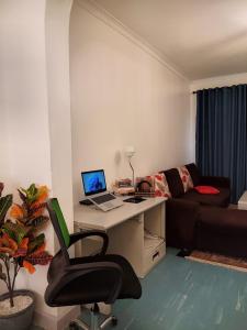 a room with a desk with a laptop and a couch at Graceland 2 in Nakuru