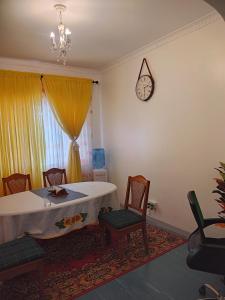 a dining room with a table and chairs and a clock at Graceland 2 in Nakuru