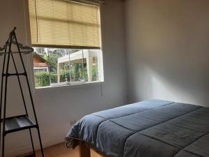 a bedroom with a blue bed and a window at Cabañitas Shollet in Oxapampa