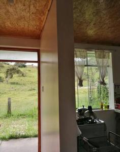 een keuken met een fornuis en uitzicht op een veld bij Cabañitas Shollet in Oxapampa