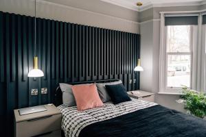 a bedroom with a bed and two night stands and a window at Sanctuary-by-Sea in Worthing