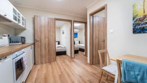 a kitchen and a living room with a table at Palmy Home Dunakeszi in Dunakeszi