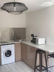 uma cozinha com uma máquina de lavar roupa e um micro-ondas em Appart des airs Mamoudzou em Mamoudzou