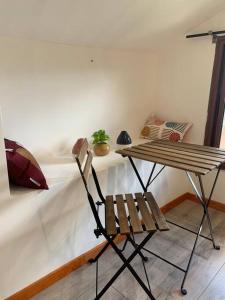 a wooden bench sitting next to a table with a chair at Appart des airs Mamoudzou in Mamoudzou