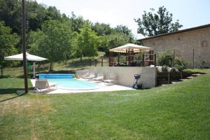 ein Swimmingpool mit Stühlen und einem Pavillon in der Unterkunft Luxury Casale Sabina Valley in Rocca Sinibalda