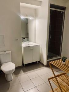 a white bathroom with a toilet and a sink at Charmant T2 moderne /proximité CDG / Confort in Villepinte