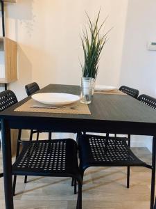 a black table with chairs and a plate on it at Charmant T2 moderne /proximité CDG / Confort in Villepinte